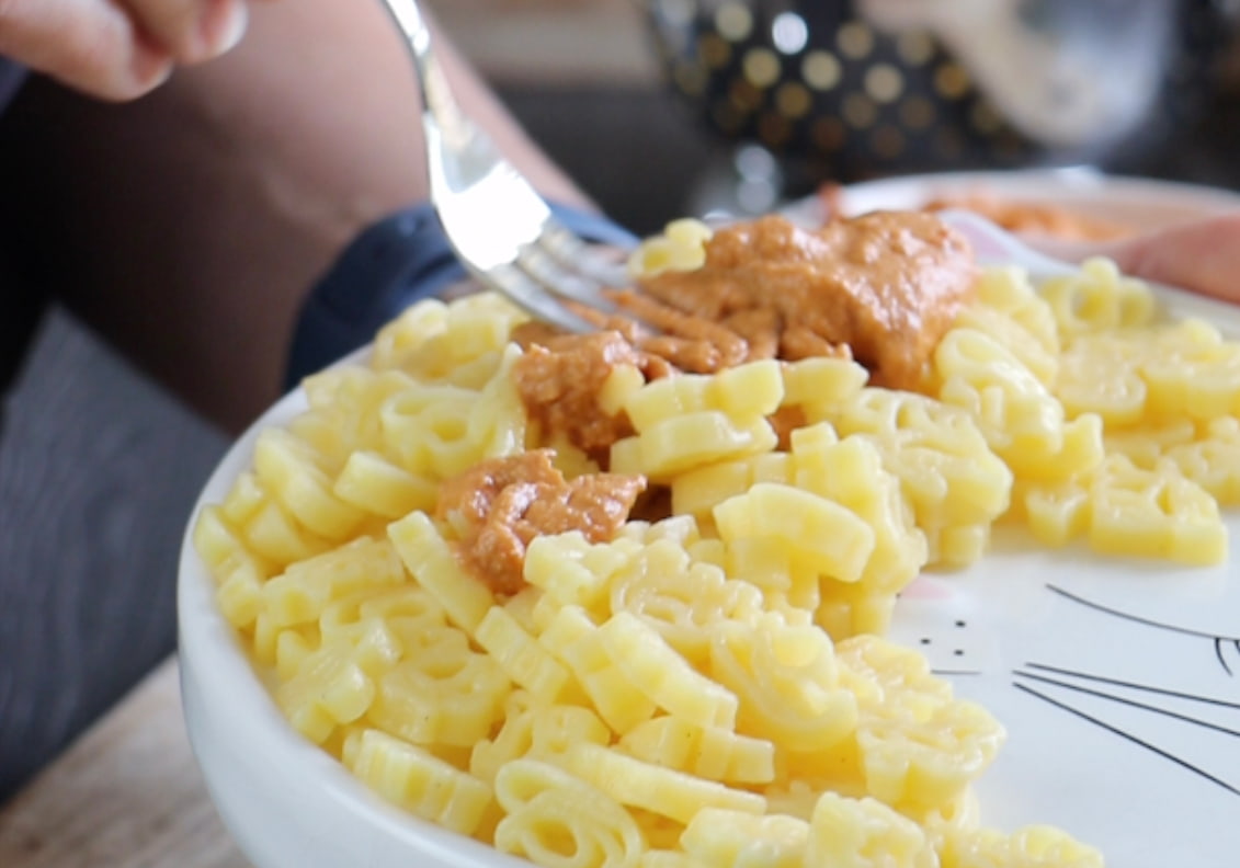 Kindernudeln mit Pesto darüber auf einem Teller angrichtet